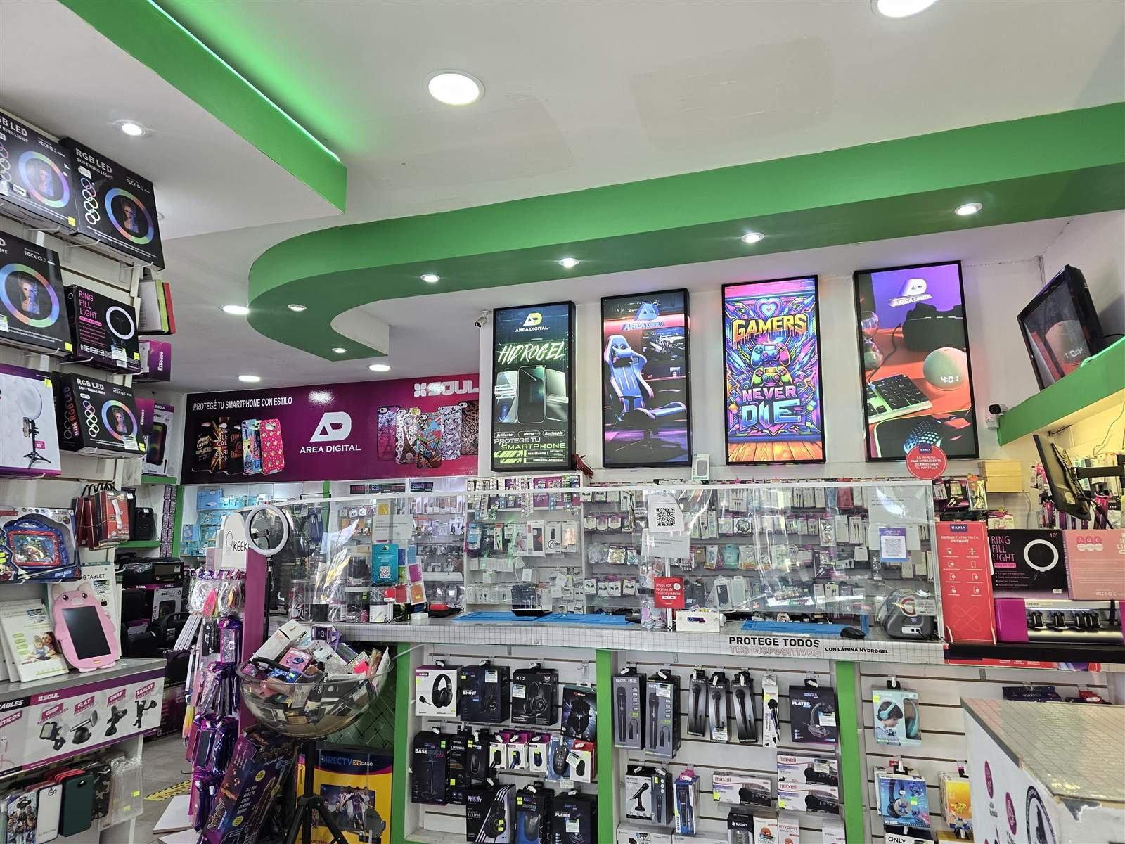 Interior del local Area Digital con pantallas de neón y vitrinas