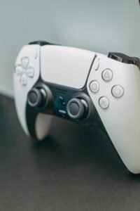 Close-up of a PlayStation 5 controller resting on its console, showcasing modern gaming technology.