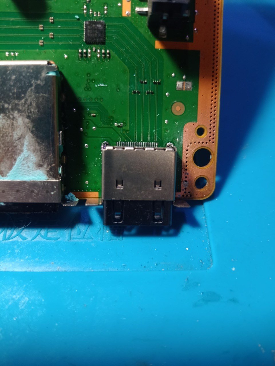 Conector HDMI nuevo soldado en la placa de una consola