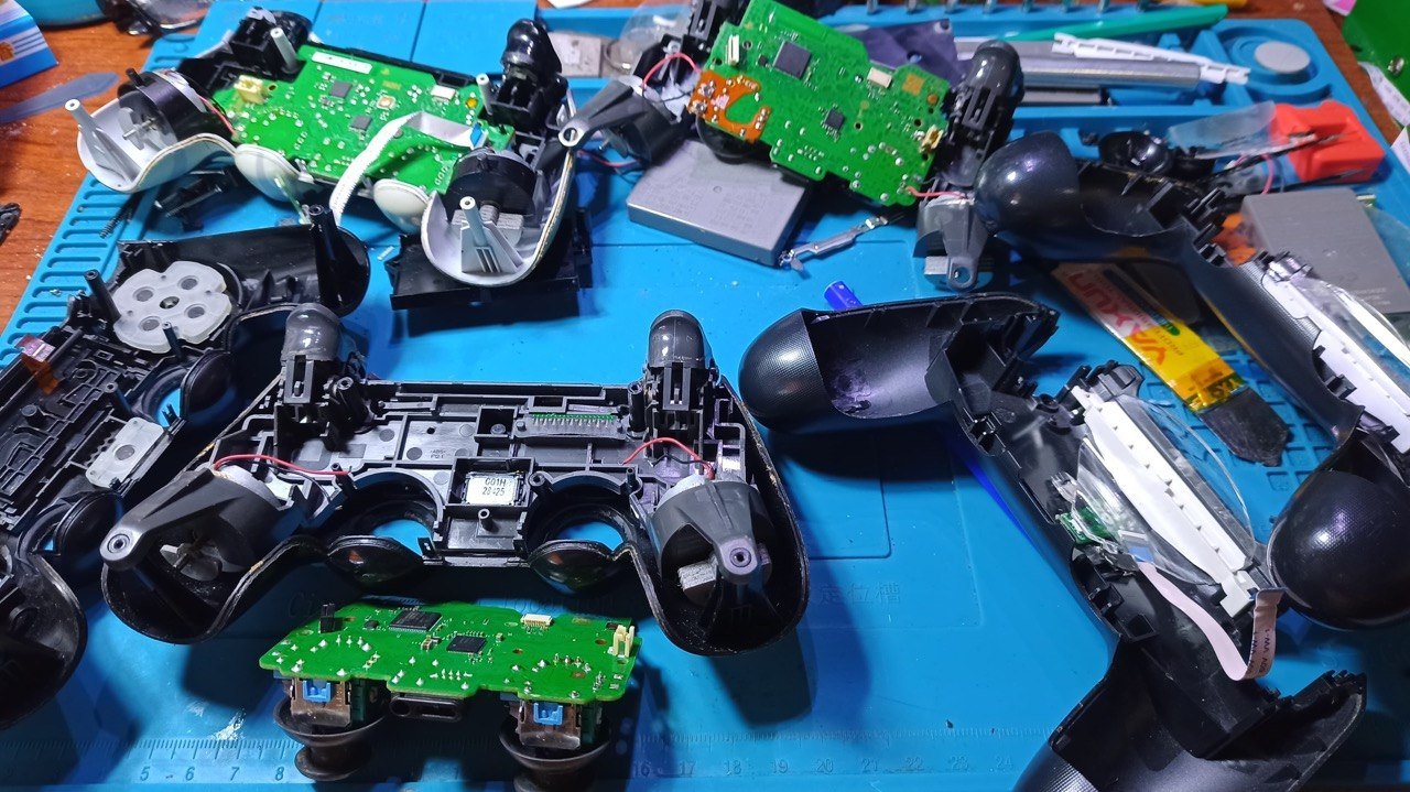 Mandos de PS4 desarmados durante una reparación en el taller