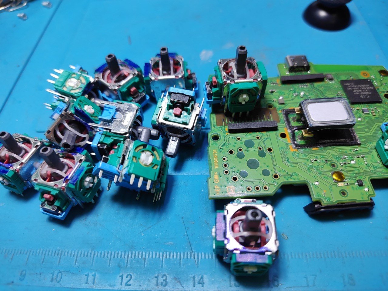 Joysticks usados junto a la placa de un mando antes del recambio