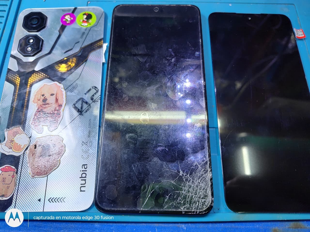 Celular con la pantalla rota junto al módulo de repuesto nuevo sobre la mesa de trabajo del servicio técnico de Area Digital