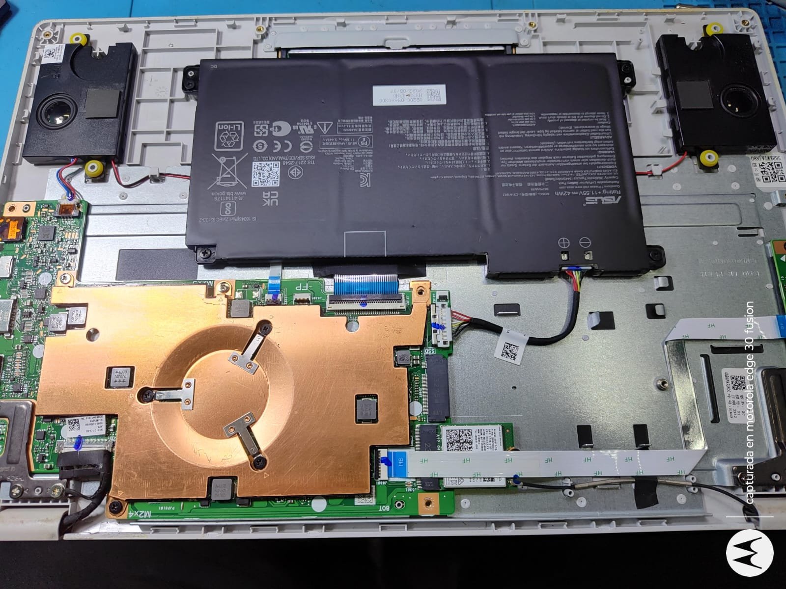 Notebook abierta en el servicio técnico de Area Digital, con la batería, el disipador y el ventilador a la vista