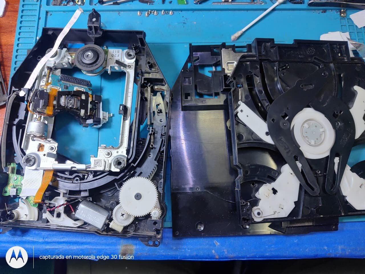 Lectora de la PS3 abierta, con el láser y los engranajes a la vista para su limpieza
