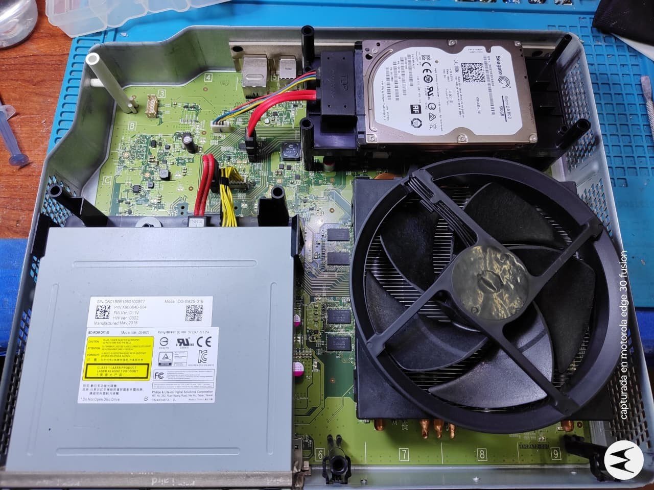 Interior de una Xbox One con lectora, disco y ventilador durante el mantenimiento de Xbox One
